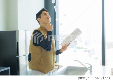 資料を見ながら打ち合わせする空調服の職人の男性 136121624
