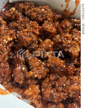 Crispy Korean fried chicken, perfectly glazed with a sweet and spicy sauce. Ideal for food photography and menus, showcasing the irresistible crunch and flavor of this beloved dish. 136122274