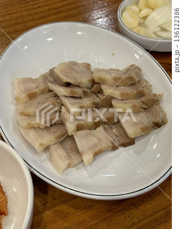 Suyuk, a traditional Korean dish of boiled pork slices, tender and juicy, often served with salted shrimp sauce, garlic, and ssamjang. Perfect for wrapping in lettuce for a flavorful, balanced bite. Suyuk, a traditional Korean dish of boiled pork slices, tender and juicy, often served with salted shrimp sauce, garlic, and ssamjang. Perfect for wrapping in lettuce for a flavorful, balanced bite. 136122386