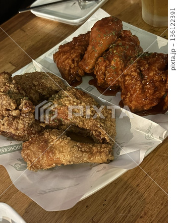 Crispy Korean fried chicken, perfectly glazed with a sweet and spicy sauce. Ideal for food photography and menus, showcasing the irresistible crunch and flavor of this beloved dish. Crispy Korean fried chicken, perfectly glazed with a sweet and spicy sauce. Ideal for food photography and menus, showcasing the irresistible crunch and flavor of this beloved dish. 136122391