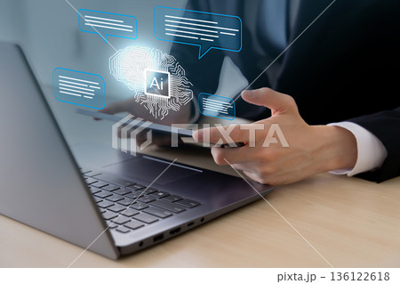 オフィスでノートパソコンとタブレットPCを使うビジネスパーソンとAI・人工知能のコンセプト 136122618