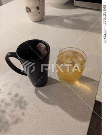 Refreshing iced tea served in a chilled glass, featuring a deep amber hue and a light citrus garnish. Perfect for a cooling and revitalizing drink on warm days. 136122842