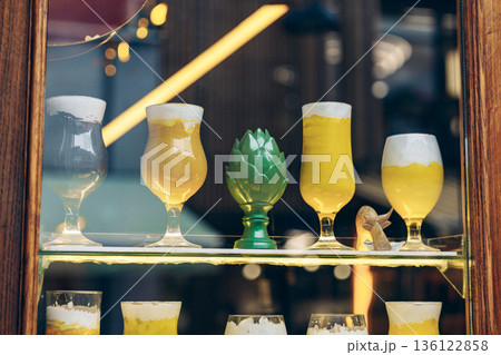 Different types of drinks displayed in a glass cabinet at a bar in the city 136122858