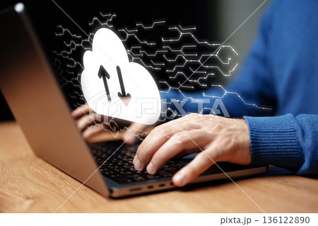 Using a laptop for cloud data transfer during daytime work session Using a laptop for cloud data transfer during daytime work session 136122890