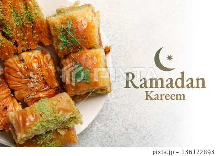 Sweets on a plate during Ramadan in a family gathering at home around evening time 136122893