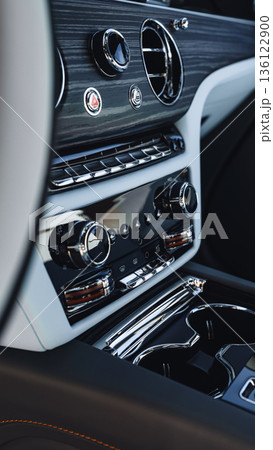 Interior details of a luxury car with controls and dashboard settings 136122900