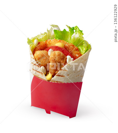 Fresh wrap with chicken, lettuce, and tomato served in a holder 136122929