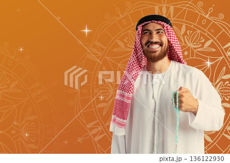 Smiling man holding prayer beads during Ramadan celebration in a colorful setting 136122930