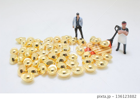 Miniature Workers Handling Stack Of Shiny Gold Ingots Miniature Workers Handling Stack Of Shiny Gold Ingots 136123882