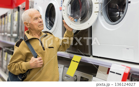 elderly man choosing washing machine in showroom of electrical appliance store 136124027