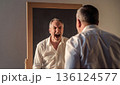 Angry man screaming at his reflection in mirror. AI-generated item 136124577