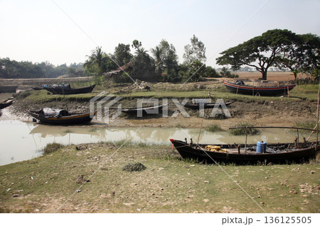 Boats of fishermen stranded in the mud at low tide on the coast of Bay of Bengal, India Boats of fishermen stranded in the mud at low tide on the coast of Bay of Bengal, India 136125505