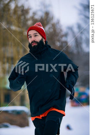 Bearded man jogging outdoors in winter park Bearded man jogging outdoors in winter park 136125671