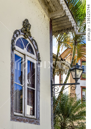 Old window decorated with a sculpture 136125744