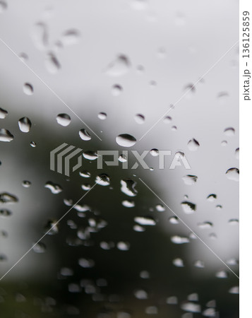 Water drops moving down clear glass window 136125859