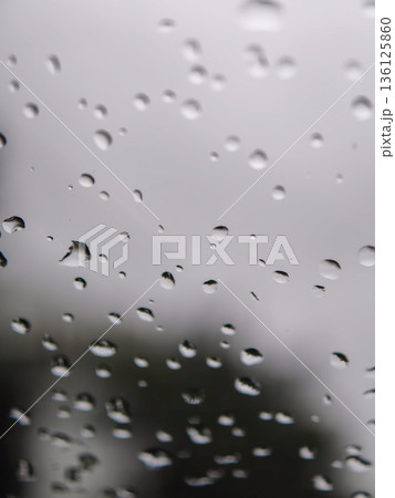 Raindrops falling on glass surface creating texture Raindrops falling on glass surface creating texture 136125860