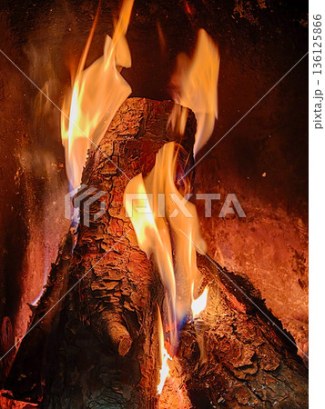 Burning wood logs creating warmth and inviting glow Burning wood logs creating warmth and inviting glow 136125866