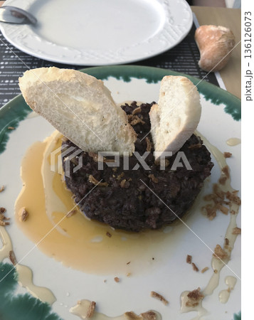 plate of black pudding cake with honey and mustard sauce decorated with bread toasts plate of black pudding cake with honey and mustard sauce decorated with bread toasts 136126073