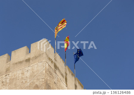 flags hoisted over the towering stone tower 136126486