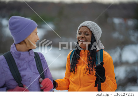 Two happy female friends enjoying winter hiking together 136127215