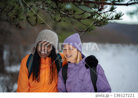 Diverse women friends enjoying winter hiking outdoors together Diverse women friends enjoying winter hiking outdoors together 136127221