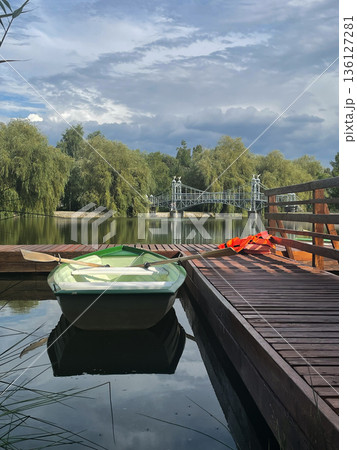 Peaceful Dock by the Lake with a Green Rowboat 136127281