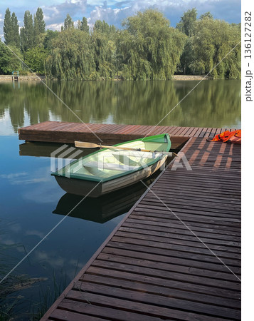 Calm Lake Scene with a Wooden Dock and Suspension Bridge 136127282