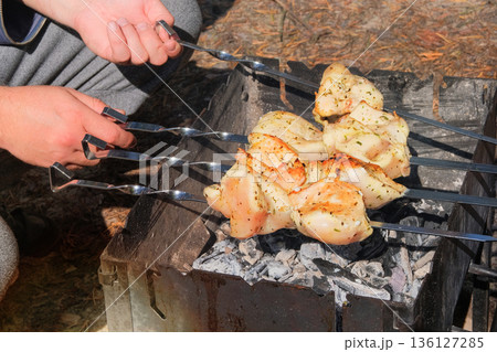 Frying meat on grill. Cook fries meat on fire. Barbecue in open air. Sunny day. Close-up. Frying meat on grill. Cook fries meat on fire. Barbecue in open air. Sunny day. Close-up. 136127285