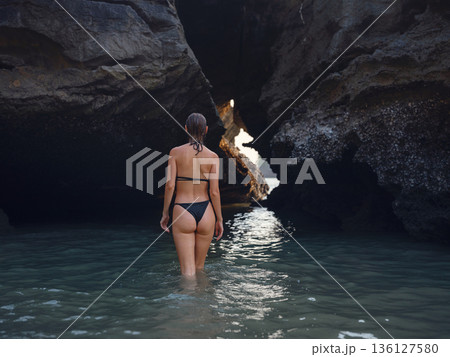 Young woman enjoying serene evening at sea in Krabi, Thailand during sunset. Calm waves, golden light, and peaceful atmosphere highlight tropical beauty and connection with nature. Young woman enjoying serene evening at sea in Krabi, Thailand during sunset. Calm waves, golden light, and peaceful atmosphere highlight tropical beauty and connection with nature. 136127580