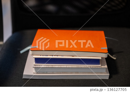 Minimal stack of notebooks and sketchbooks on dark background 136127705
