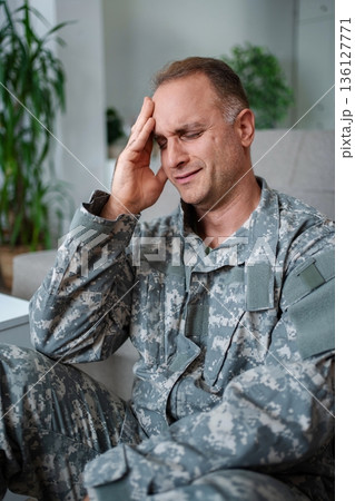 Soldier suffering from post-traumatic stress disorder having a headache at home Soldier suffering from post-traumatic stress disorder having a headache at home 136127771