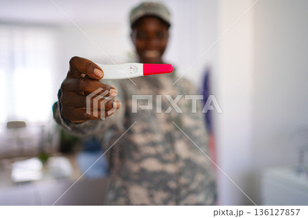 Soldier woman showing positive pregnancy test Soldier woman showing positive pregnancy test 136127857