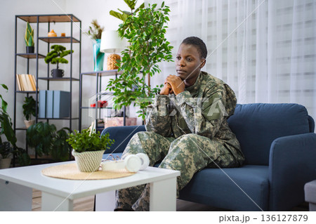 Depressed african american soldier sitting on sofa at home 136127879