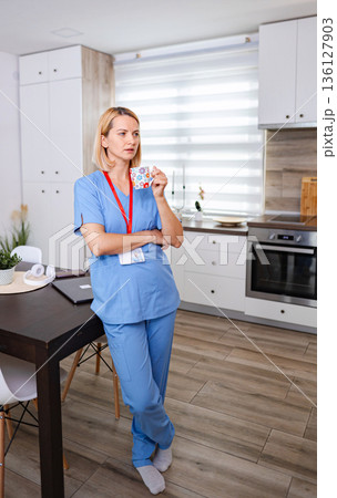 Nurse drinking coffee during break time in the kitchen Nurse drinking coffee during break time in the kitchen 136127903