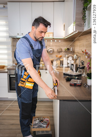 Handyman measuring kitchen counter using tape measure Handyman measuring kitchen counter using tape measure 136127939