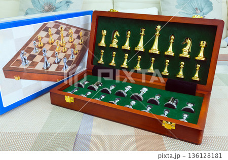 chessboard with golden and silver pieces isolated close-up 136128181