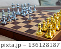 chessboard with golden and silver pieces isolated close-up 136128187