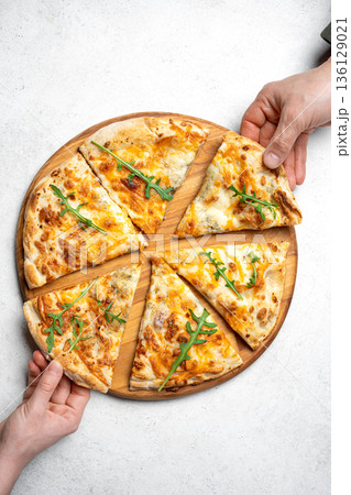 Hands grabbing slices of pizza 136129021
