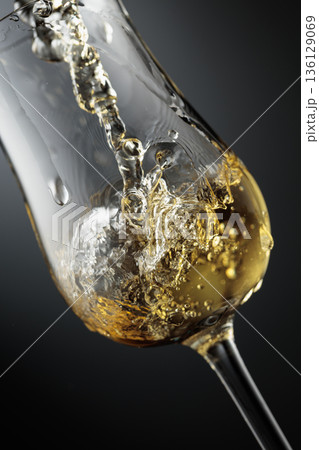 Whiskey is poured is poured into a glass. Whiskey is poured is poured into a glass. 136129069