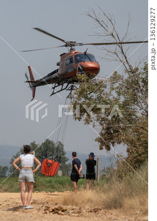 Helicopter in Action with Onlookers Observing 136129277