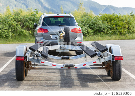 Empty boat trailer connected to the car. Trailer for boats roots Empty boat trailer connected to the car. Trailer for boats roots 136129300