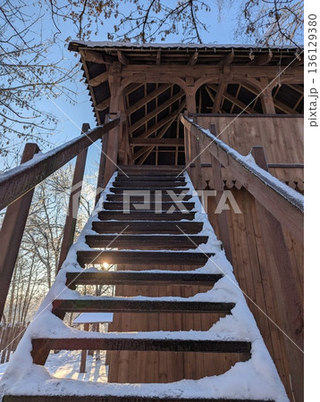 An ancient wooden fortress tower with a staircase, wintertime 136129380
