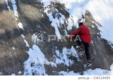 Man climbing on snowy rock formation at national park. Winter sport adventure travel, rock climbing, and outdoor activity concept. 136129485