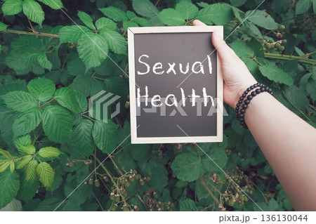 Person holds a chalkboard with the word sexual health written on it 136130044