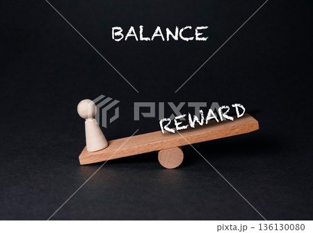 Wooden balance scale with a figurine representing reward and balance concept in minimalistic design 136130080