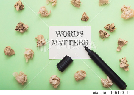 Creative workspace with handwritten note saying "Words Matter" surrounded by crumpled paper Creative workspace with handwritten note saying "Words Matter" surrounded by crumpled paper 136130112