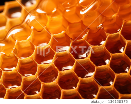 Close-up of honeycomb structure showcasing golden honey dripping from hexagonal cells Close-up of honeycomb structure showcasing golden honey dripping from hexagonal cells 136130576