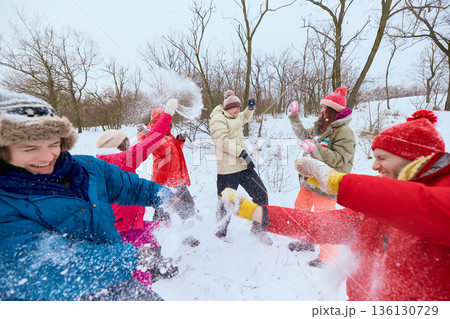 Group of friends having snowball fight in winter park. 136130729