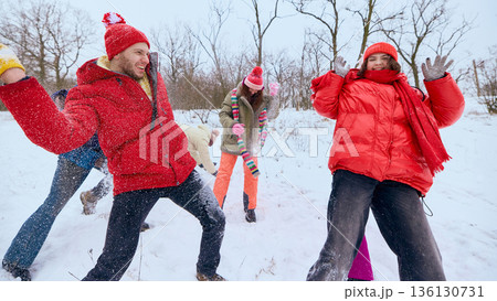 Friends running and throwing snow in winter park. 136130731