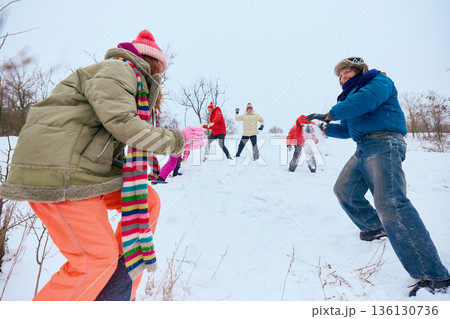Group of friends playing snowball fight. 136130736